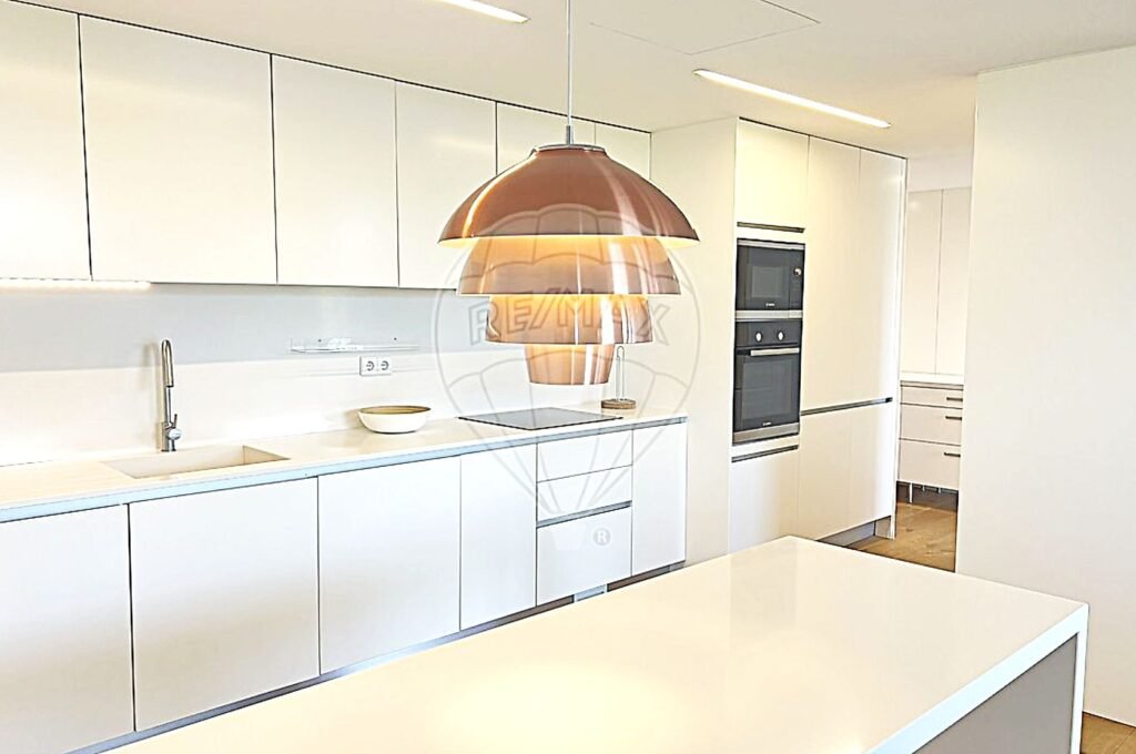 Side profile of a modern kitchen featuring sleek cabinetry and integrated appliances.