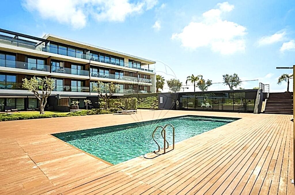 Wide exterior shot of the modern Sector 5 apartment building featuring a sleek swimming pool in the foreground.