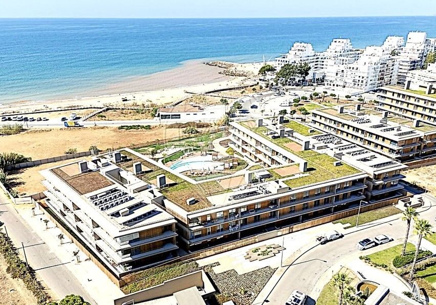Aerial view of newly completed T2 frontline apartment at Horizon Ocean Gardens, Quarteira, Algarve, featuring infinity pool, underground parking, and panoramic ocean views.