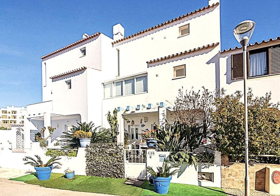 Front view of three-bedroom townhouse in Beco do Romão, Quarteira, Algarve, with multi-level layout and 300 meters from the beach.